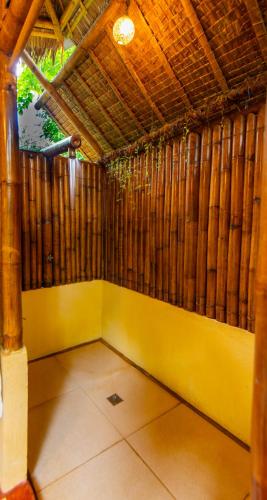 a room with a yellow wall and wooden walls at Water to Forest Ecolodge in Loboc
