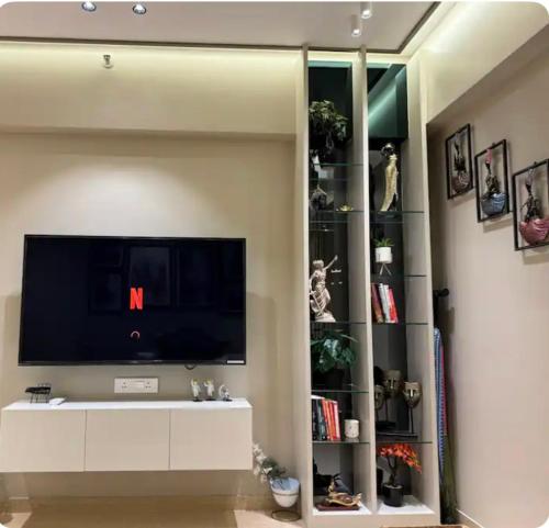 a living room with a flat screen tv on a wall at The Manor in Pune