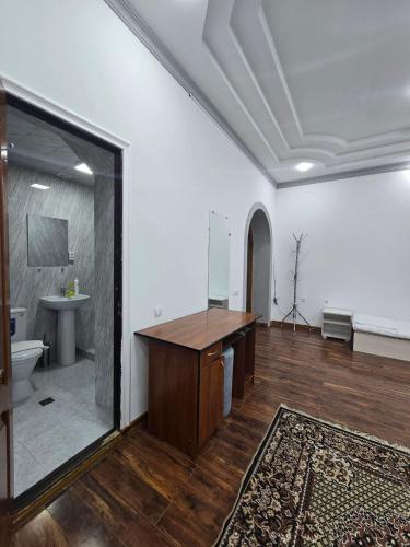 una grande stanza con una scrivania e un lavandino di GUESTO HOSTEL a Tashkent