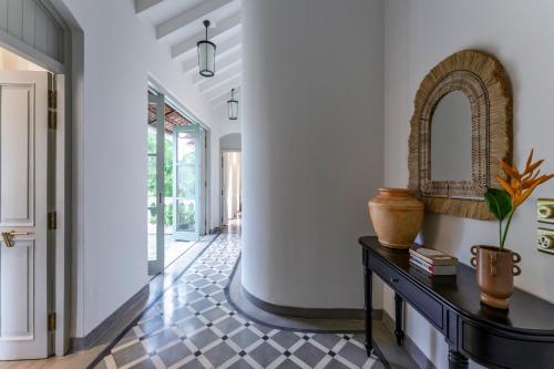 a hallway with a console table and a mirror at La Rozalia, Exquisite 4 BHK Villas with Large Pool, Garden, Dedicated Caretaker, Terrace, 2 mins from the famous Dear Zindagi Road in Mapusa