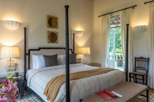 a bedroom with a large bed and a balcony at La Rozalia, Exquisite 4 BHK Villas with Large Pool, Garden, Dedicated Caretaker, Terrace, 2 mins from the famous Dear Zindagi Road in Mapusa