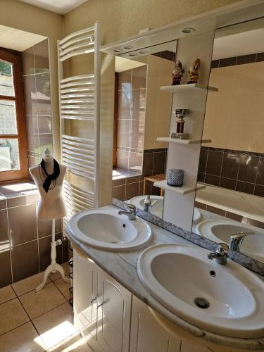 une salle de bain avec deux lavabos et un miroir dans l'établissement Château de la Reynerie, à Toiras