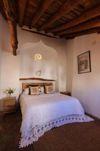 a bedroom with a large white bed with pillows at Casalar in Alhama de Granada