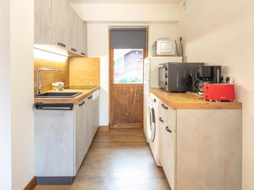 une petite cuisine avec un évier et un réfrigérateur dans l'établissement Bel appartement rénové · Balcon · Proche pistes et commerces · Casier à ski - FR-1-181-2460, à La Plagne Tarentaise
