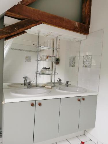 - une salle de bains blanche avec deux lavabos dans l'établissement La chambre des vergers de St Nicolas, à Mayet