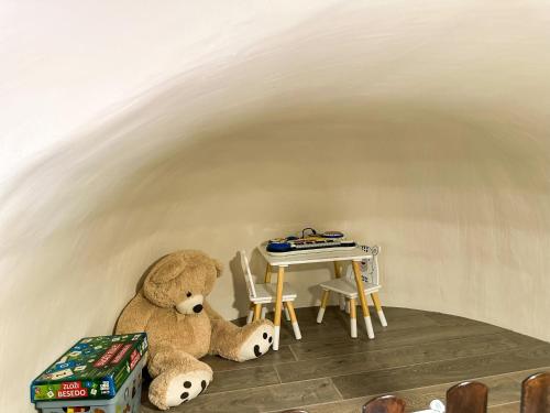 a teddy bear sitting next to a table in a room at Krka Fairytale village in Rupe