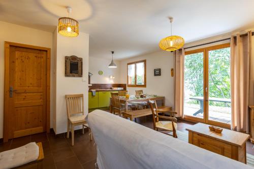 a living room with a table and a dining room at Chalet 70 m2 - Risoul Village - à 15 mn des pistes in Risoul