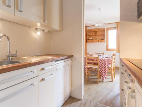 une petite cuisine avec un évier et une table dans l'établissement Apt Chaleureux Proche Pistes avec Balcon & TV - Montchavin - FR-1-181-2506, à La Plagne Tarentaise