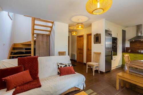 un salon avec un canapé blanc et une cuisine dans l'établissement Chalet 70 m2 - Risoul Village - à 15 mn des pistes, à Risoul