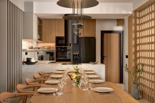 a long wooden table with chairs in a kitchen at Ficus Seafront Villa, Eco Pool & Close to Beach, By ThinkVilla in Balíon
