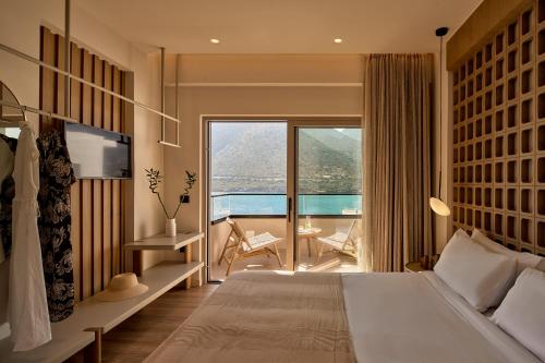 a bedroom with a large bed and a balcony at Ficus Seafront Villa, Eco Pool & Close to Beach, By ThinkVilla in Balíon