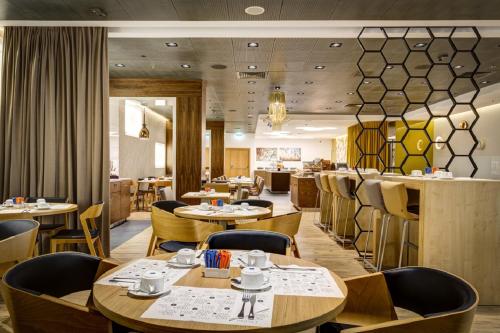 a restaurant with tables and chairs and a bar at Novotel Warszawa Centrum in Warsaw