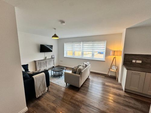 a living room with two couches and a window at Inchconnachan Apartment in Bonhill