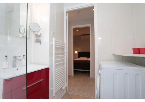 - une salle de bains blanche avec lavabo et une chambre avec un lit dans l'établissement T2 centre-ville Banane à Cannes avec grande terrasse, à Cannes