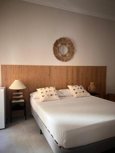 a bedroom with a white bed with a mirror on the wall at Chiaia 100 rooms in Naples