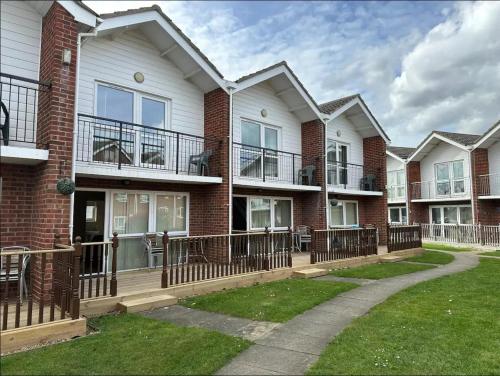 a row of houses with balconies and a sidewalk at Coastal Retreat at Waterside Park in Corton