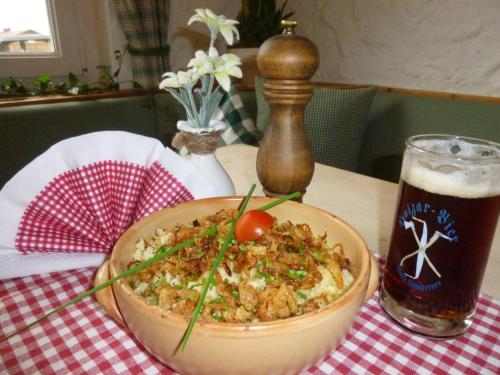 a bowl of food on a table with a glass of beer at Riedbergerhorn - Gasthof & Ferienwohnungen in Bolsterlang