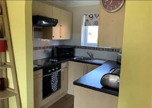a small kitchen with a stove and a sink at Coastal Retreat at Waterside Park in Corton