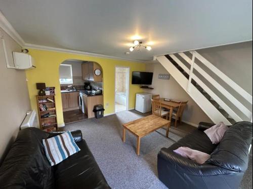 a living room with a couch and a table at Coastal Retreat at Waterside Park in Corton