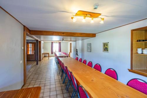 a conference room with a long table and red chairs at Berismenil Gardens large villa with indoor swimming pool and jacuzzi in La Roche-en-Ardenne