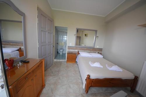 a bedroom with a bed and a bathroom with a mirror at Bikakis Family Apartments in Kissamos