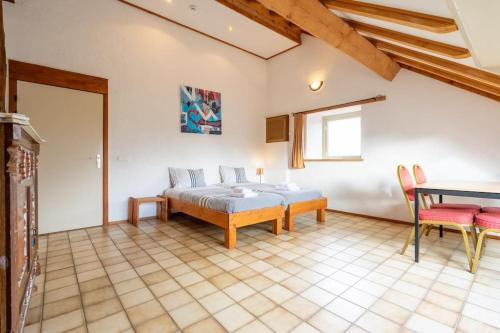 a bedroom with a bed and a table at Berismenil Gardens large villa with indoor swimming pool and jacuzzi in La Roche-en-Ardenne