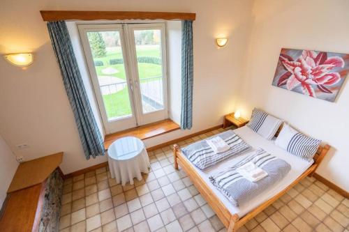 a bedroom with a bed and a large window at Berismenil Gardens large villa with indoor swimming pool and jacuzzi in La Roche-en-Ardenne