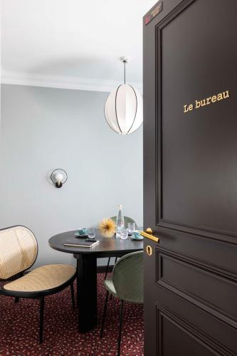 a dining room with a table and chairs and a door at LE CLARK HOTEL in Paris