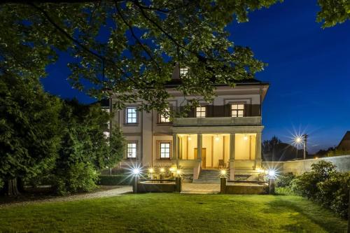 a house with lights on the lawn at night at Hotel Zámeček Raspenava in Raspenava
