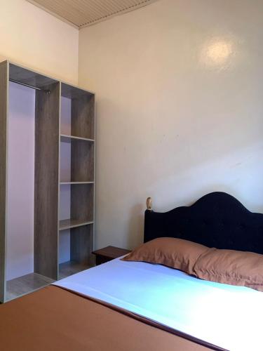a bedroom with a bed and a book shelf at Kivu Haven Kigali in Kigali