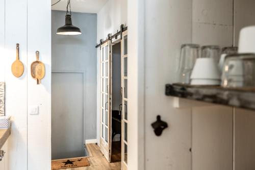 una cucina con una porta che conduce a una stanza con pareti bianche di Lo.f.t ô village a Monflanquin