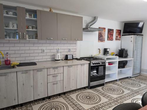una cucina con mobili bianchi e un forno a piano cottura di Cazare La Piatra Buhei a Câmpulung Moldovenesc