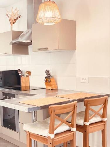 - une cuisine avec une table et deux chaises en bois dans l'établissement Maison avec petite piscine Arcachon Bordeaux, à Mios