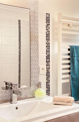 une salle de bain blanche avec un lavabo et un miroir dans l'établissement Maison avec petite piscine Arcachon Bordeaux, à Mios