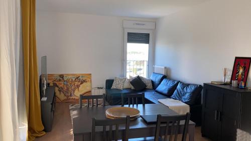 un salon avec un canapé bleu et une table dans l'établissement Appartement entier vue Seine, à Paris