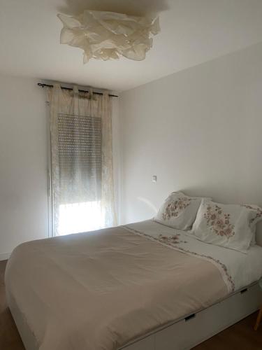 une chambre blanche avec un lit et une fenêtre dans l'établissement Appartement entier vue Seine, à Paris