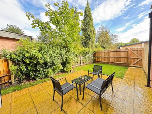 a patio with chairs and a table and a fence at The Phantom Apartment 1 minute walk to JR, Churchill Manor Nuffield Hospitals Oxford B Uni, Sleeps 5 Guests comfortably very modern 2 rooms 3 bathrooms Private Garden in Oxford