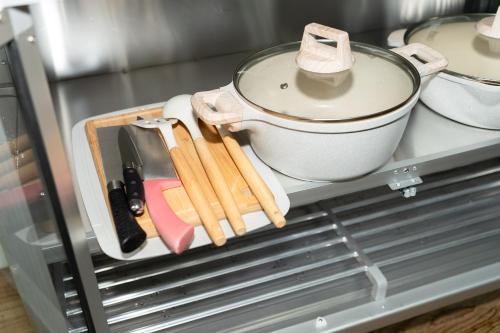 a pot and utensils on a shelf in a refrigerator at Pillow BKK Bliss townhome 5BR,7TL near BTS&MRT QSCC in Khlong Toei