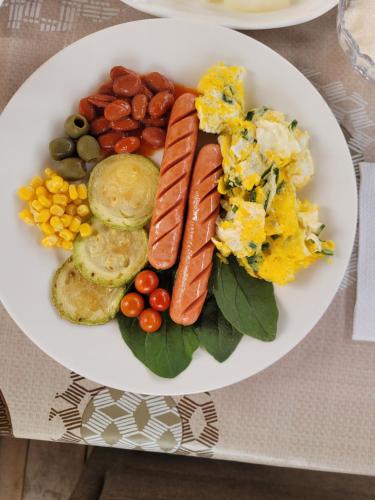 a plate of food with sausage and vegetables on a table at Jashylkent House in Vorontsovskoye