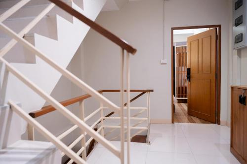 a staircase in a house with a wooden door at Pillow BKK Bliss townhome 5BR,7TL near BTS&MRT QSCC in Khlong Toei