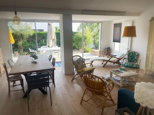 un salon avec une table et des chaises dans l'établissement Villa cosy à deux pas de la plage - Classée 3 étoiles, à Les Sables-dʼOlonne