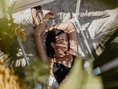 a woman is sitting on a hammock at Spa Resort Geinberg in Geinberg