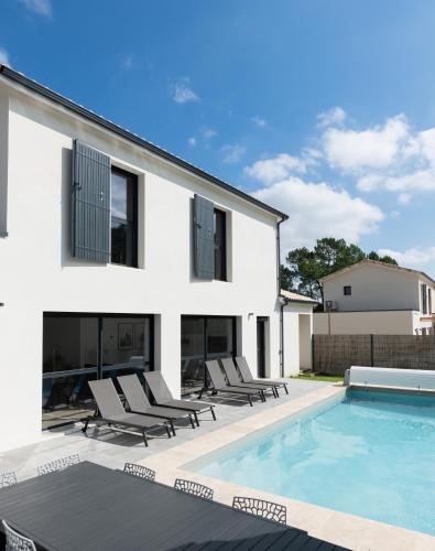 une maison avec une piscine et des chaises longues dans l'établissement Villa 4 chbres avec piscine (10), à Saint-Augustin
