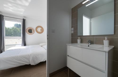 une salle de bain avec un lit, un lavabo et un miroir dans l'établissement Villa 4 chbres avec piscine (10), à Saint-Augustin