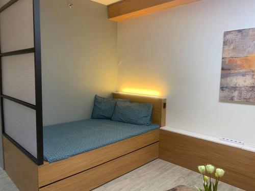 a small bed with blue pillows in a room at Tranquil - Unit in Nuvali located at 5th floor w Balcony in Lagundi
