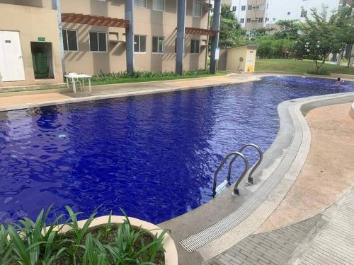 a large blue swimming pool in front of a building at Tranquil - Unit in Nuvali located at 5th floor w Balcony in Lagundi