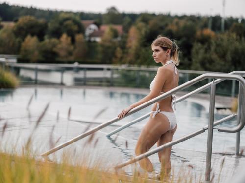 a young woman in a bikini walking down a hand rail at Spa Resort Geinberg in Geinberg