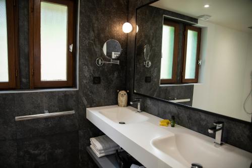 a bathroom with two sinks and a mirror at ISKÖ CHALETS-HÖTEL, Col d'Aubisque in Gourette