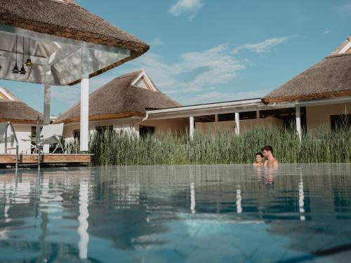 two people swimming in a pool at a resort at Spa Resort Geinberg in Geinberg