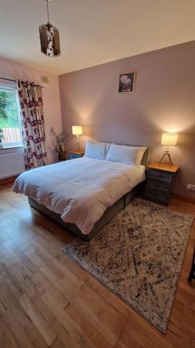 a bedroom with a large bed and a rug at Benroe House 5 Bedrooms in Killybegs